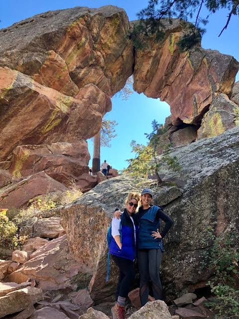 Two hikers standing beneath the Royal Arch, showing its scale.